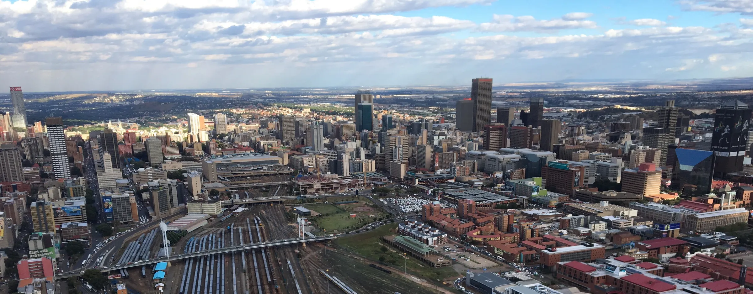 Central Johannesburg from above: office towers, rail yards and the city stretching to the horizon.